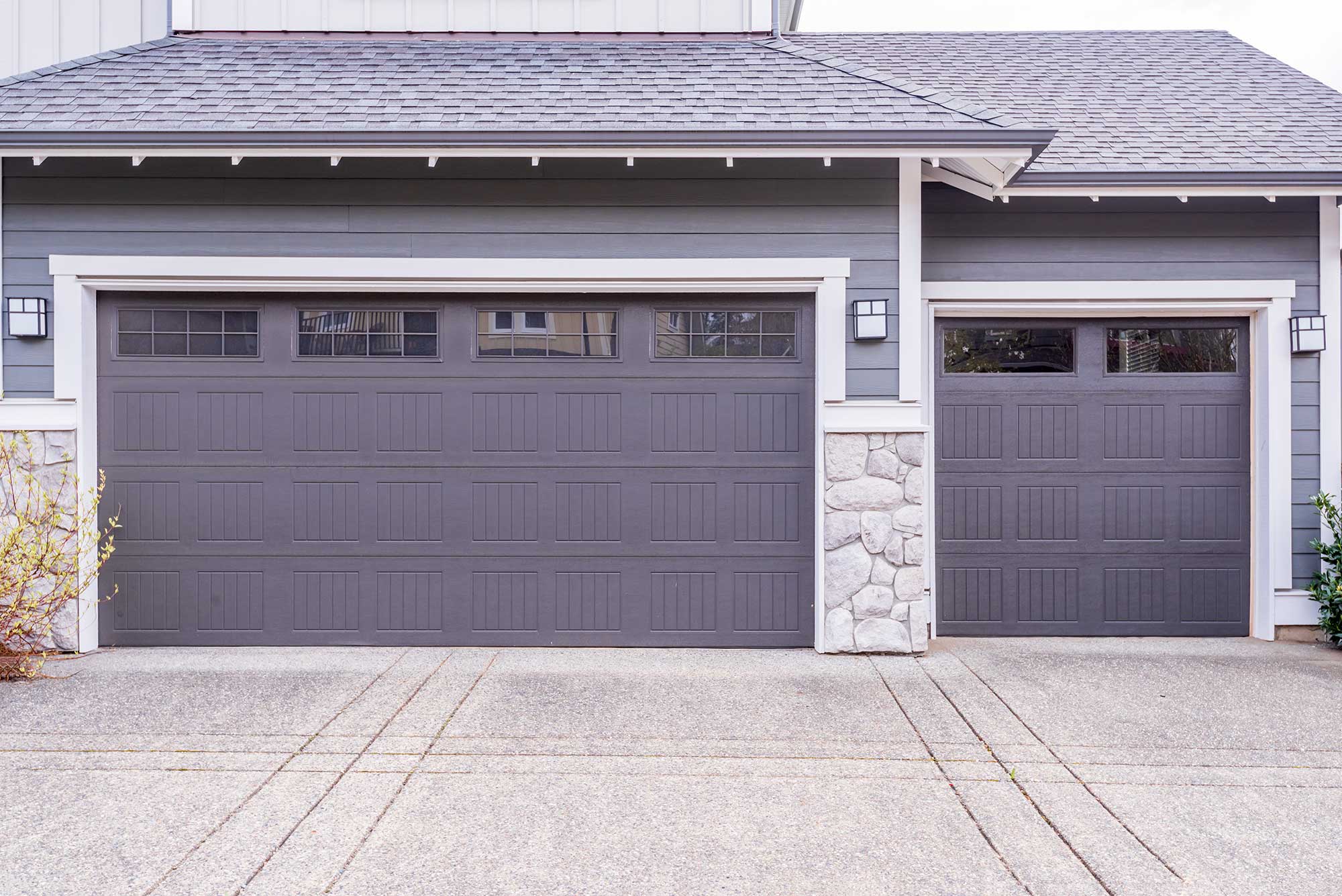 Double and single-width metal garage doors with top windows.